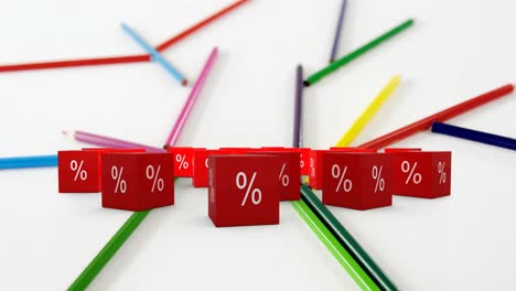 Animation-of-percent-sales-symbol-on-red-cubes-and-colour-pencils-on-white-background