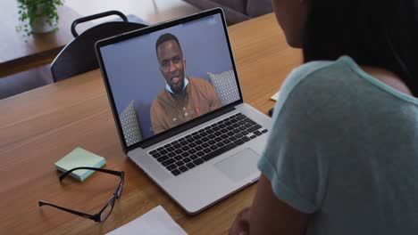 Afroamerikanische-Frau-Führt-Zu-Hause-Einen-Videoanruf-Mit-Einem-Männlichen-Bürokollegen-Auf-Einem-Laptop