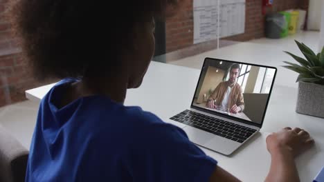 Afroamerikanische-Frau-Spricht-Per-Videoanruf-Mit-Einem-Männlichen-Kollegen-Am-Laptop-Im-Büro