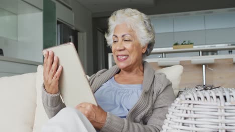 Afroamerikanische-ältere-Frau-Lächelt,-Während-Sie-Zu-Hause-Einen-Videoanruf-Auf-Einem-Digitalen-Tablet-Führt