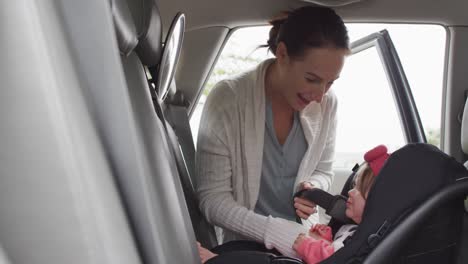 Caucasian-mother-keeping-her-baby-in-safety-seat-in-the-car