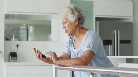 Afroamerikanische-ältere-Frau,-Die-Zu-Hause-Ihr-Smartphone-Benutzt