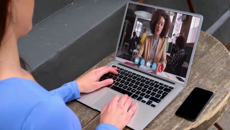 Mid-section-of-caucasian-woman-having-a-video-call-with-female-colleague-on-laptop