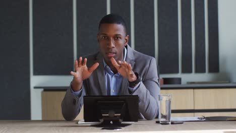 African-american-businessman-talking-on-video-call-in-conference-room-in-modern-office
