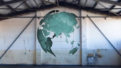 Animation-of-spinning-green-globe-over-empty-warehouse