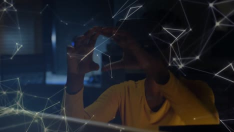 Animation-of-networks-of-connections-over-woman-using-vr-headset-in-background