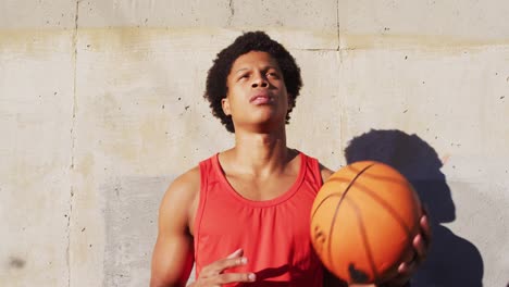 Fitter-Afroamerikanischer-Mann,-Der-Draußen-In-Der-Stadt-Trainiert-Und-Basketball-Spielt