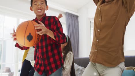 Aufgeregt-Asiatische-Eltern-Mit-Tochter-Und-Sohn-Auf-Der-Couch-Mit-Basketball,-Sport-Im-Fernsehen-Schauend,-Jubelnd