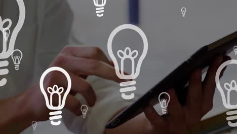 Animation-of-light-bulbs-over-woman-using-tablet-in-background