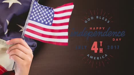 Animation-of-happy-independence-4th-of-july-text-over-person-holding-american-flag