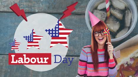 Animation-of-labour-day-text-over-smiling-woman-in-party-hat-holding-lollipop-and-fast-food