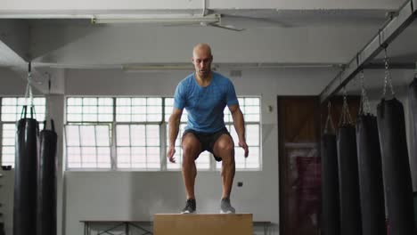 Fitter-Kaukasischer-Mann,-Der-Im-Fitnessstudio-Auf-Eine-Pylo-Box-Springt