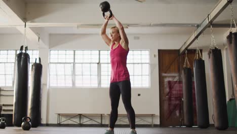 Fit-caucasian-woman-working-out-with-kettle-bell-at-the-gym