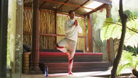 Caucasian-man-practicing-yoga-and-meditating-at-vacation-home