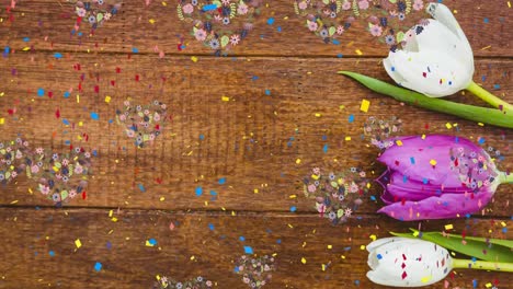 Animation-of-confetti-falling-over-wooden-surface-and-flowers
