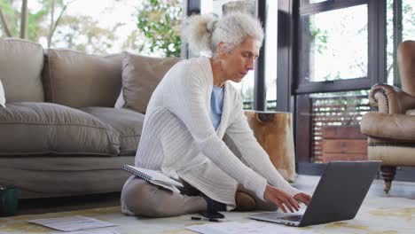 Mujer-Mayor-De-Raza-Mixta-Sentada-En-El-Suelo-Usando-Una-Computadora-Portátil