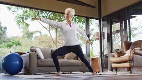 Senior-mixed-race-woman-practicing-yoga,-stretching