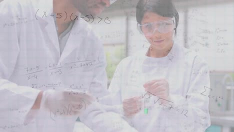 Mathematical-equations-floating-against-male-and-female-health-workers-working-at-laboratory
