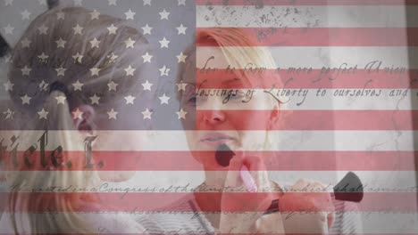 American-flag-and-constitution-text-against-caucasian-daughter-doing-makeup-of-her-mother-at-home