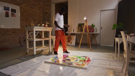 Afroamerikanischer-Männlicher-Künstler,-Der-Im-Kunstatelier-Farbe-Auf-Leinwand-Gießt
