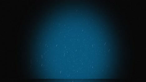 Animation-of-snow-falling-in-spotlight-on-blue-background