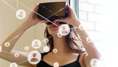 Animation-of-network-of-connections-with-icons-over-woman-wearing-vr-headset