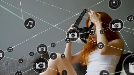 Netzwerk-Digitaler-Symbole-Gegen-Kaukasische-Frau,-Die-Zu-Hause-Ein-VR-Headset-Trägt