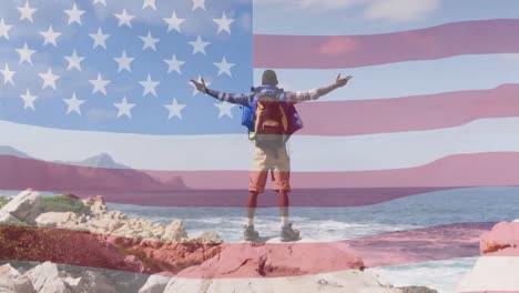 Animation-of-american-flag-moving-over-man-widening-his-arms-on-beach