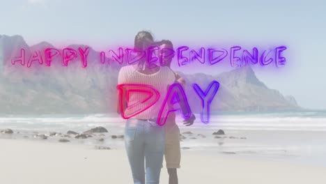 Animation-of-text-independence-day-over-african-american-couple-dancing-at-beach