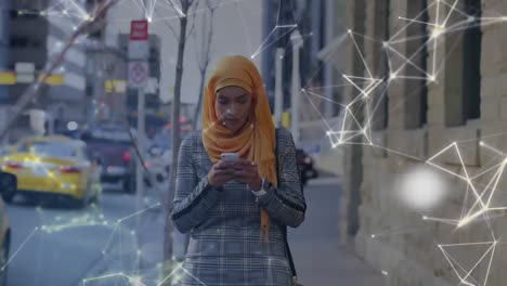 Globo-Giratorio-Y-Red-De-Conexiones-Contra-Una-Mujer-Con-Hijab-Usando-Un-Teléfono-Inteligente-En-La-Calle