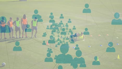 Animation-of-network-of-connections-with-people-icons-over-football-players-practicing