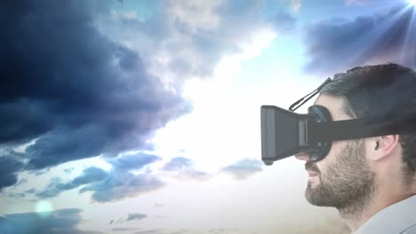 Side-view-of-caucasian-man-wearing-vr-headset-against-spot-of-light-and-clouds-in-the-sky