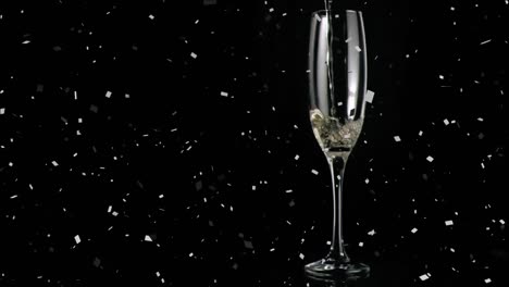 Animation-of-champagne-glass-with-confetti-falling-on-black-background