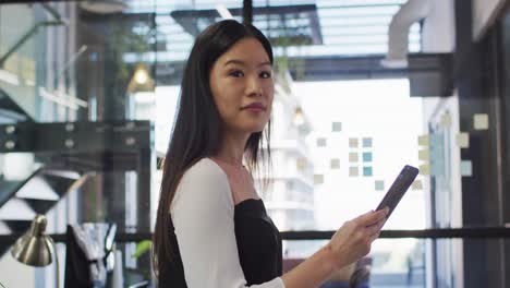 Porträt-Einer-Asiatischen-Geschäftsfrau,-Die-Ein-Tablet-Benutzt-Und-Lächelnd-In-Die-Kamera-Blickt