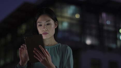 Video-Einer-Nachdenklichen-Asiatischen-Geschäftsfrau,-Die-Nachts-Im-Büro-Ein-Tablet-Benutzt