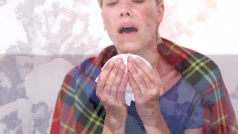 Animation-of-ill-woman-wearing-blanket-sneezing-into-tissue,-over-macro-virus