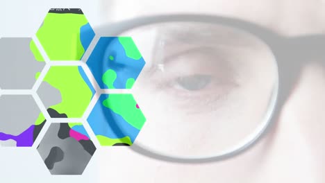 Animation-of-blinking-blue-eye-through-glasses,-with-colourful-blobs-in-hexagons,-on-white
