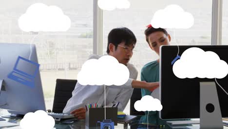 Animation-Von-Wolken-Und-Digitalen-Symbolen-über-Geschäftsleuten,-Die-Computer-Nutzen