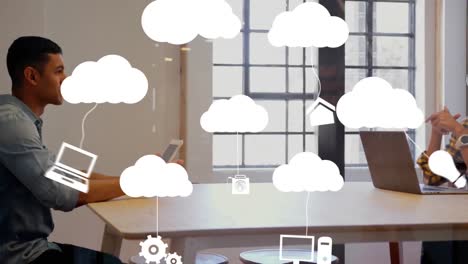 Animation-Von-Wolken-Und-Digitalen-Symbolen-über-Einer-Geschäftsfrau,-Die-Einen-Laptop-Benutzt