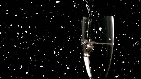 Animation-of-confetti-falling-and-champagne-pouring-into-glass-of-champagne-on-black-background
