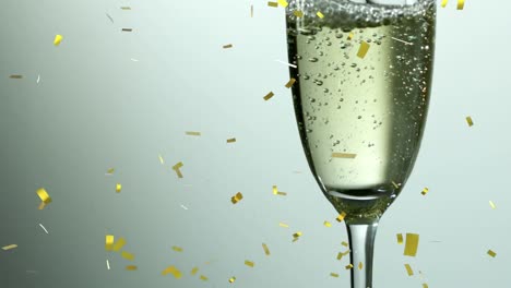 Animation-of-confetti-falling-and-bubbles-rising-in-glass-of-champagne,-on-grey-background