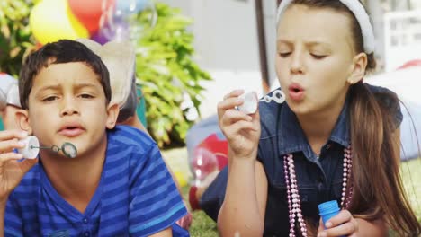 Animation-of-burned-layer-over-children-blowing-bubbles-and-having-fun-at-party