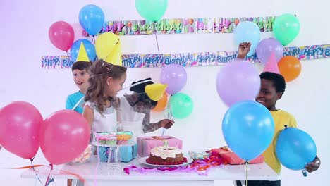 Animation-Von-Kindern,-Die-Kerzen-Auf-Der-Geburtstagstorte-Ausblasen-Und-Auf-Der-Party-Feiern