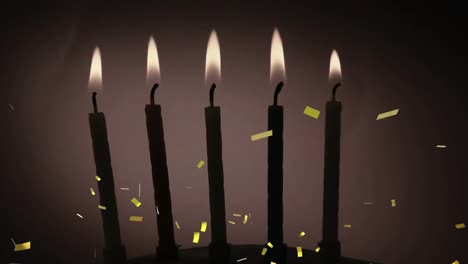 Golden-confetti-falling-over-silhouette-of-multiple-burning-candles-against-grey-background