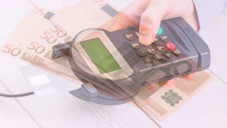 Animation-of-euro-banknotes-falling-over-hand-of-caucasian-man-holding-payment-terminal