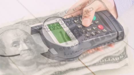 Animation-of-dollar-banknotes-falling-over-hand-of-caucasian-man-holding-payment-terminal