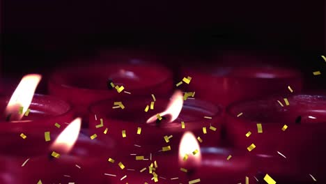 Animation-of-golden-confetti-over-red-candles