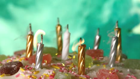 Digital-composition-of-golden-confetti-falling-over-burning-candles-on-a-cake