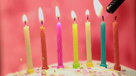 Animation-of-gold-confetti-falling-over-colourful-birthday-cake-candles-being-lit-on-cake
