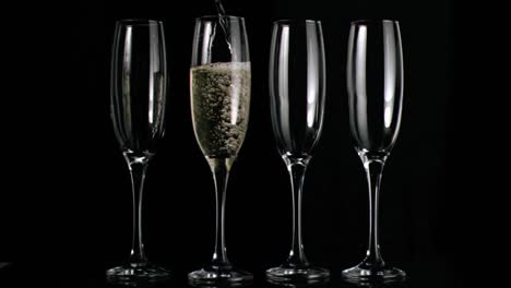 Animation-of-red-circles-spinning-over-glasses-of-champagne-on-black-background